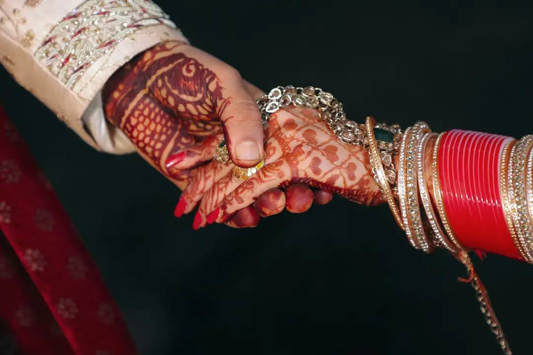 Hands with intricate bridal henna held together